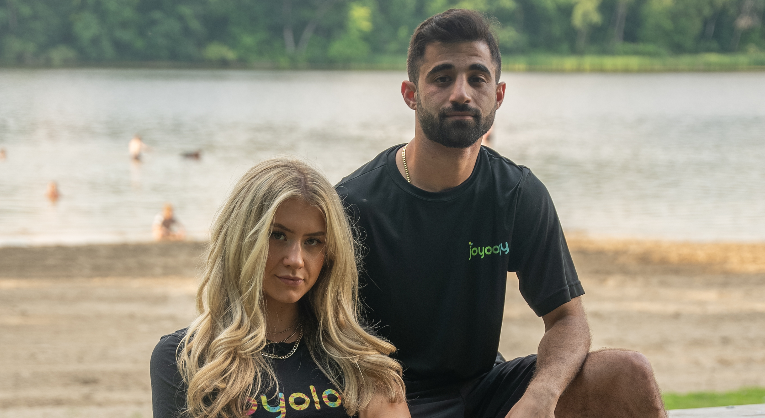 Female and male wearing Joyology merch